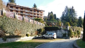 A residential area with a white car parked in front of a building with multiple balconies. - Rosemary 1 apartment in Agra with pool (Agra)