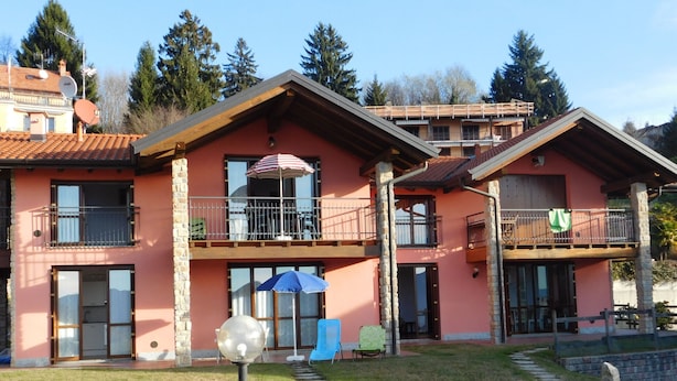 A two-story building with balconies, a visible satellite dish, and a paved pathway leading to the entrance. - Rosemary 1 apartment in Agra with pool (Agra)