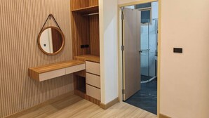 Un baño moderno con tocador de madera, espejo y zona de ducha.