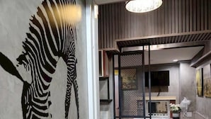 Une cuisine moderne dotée d’une cuisinière intégrée, d’un coin repas avec un banc et d’une fresque représentant des zèbres sur le mur.