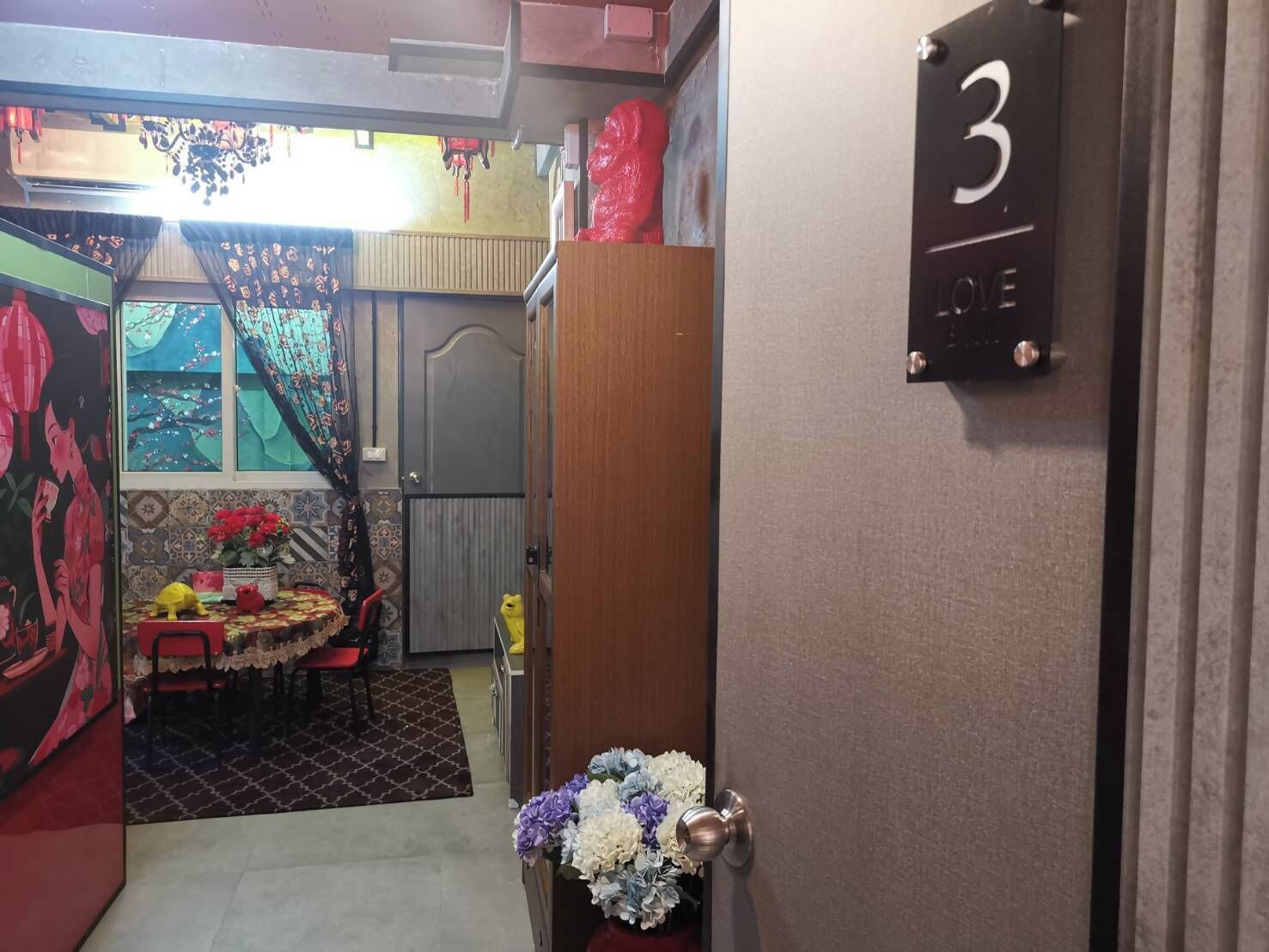 Una habitación con zona de comedor, una puerta con el número 3 y una pequeña mesa con sillas.