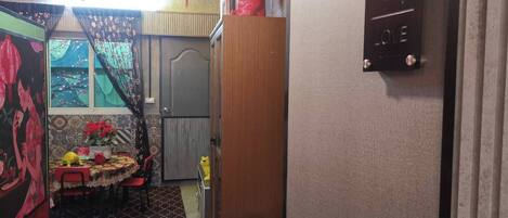 Una habitación con zona de comedor, una puerta con el número 3 y una pequeña mesa con sillas.