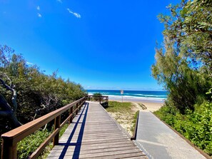 A wooden boardwalk leading to a beach with a clear view of the ocean. - Sunshine Coast, Mount Coolum,  Beach Summer holiday house - steps to the sand (Mount Coolum)