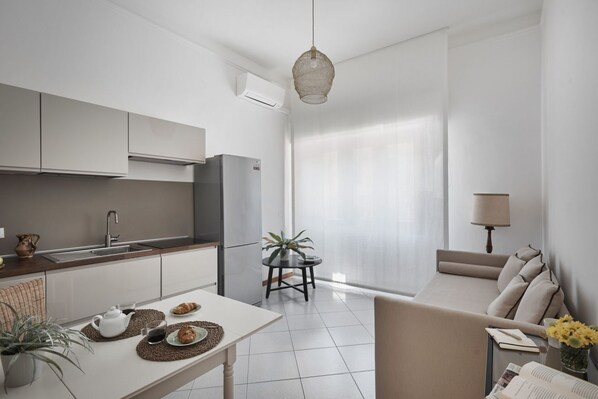 Una cocina moderna con comedor, sofá y vistas al exterior.