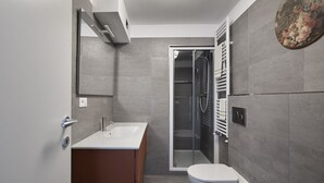 A modern bathroom with a shower, toilet, and sink. - Green H- Earth Suite for 2 persons (Florence)