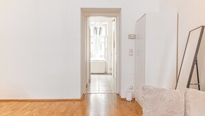 Käytävän lattia on tehty puusta, ja se johtaa ovelle, jonka läpi näkyy patteri.