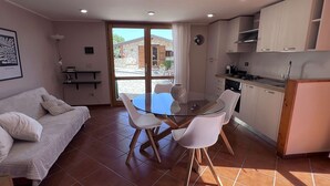 A compact living space with a dining area, kitchenette, and a sofa. - Villa Romy with shared pool and garden - My Rental Homes (Castellammare Del Golfo)