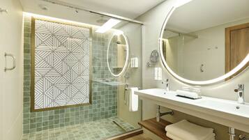 A modern bathroom with a shower, a vanity with a mirror, and a towel rack.