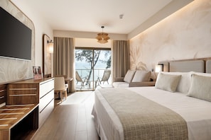 Una habitación de hotel moderna con una cama grande, un escritorio, una silla y un balcón con vistas al mar.
