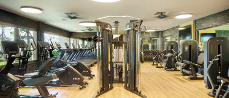 A gym with various exercise equipment, including treadmills, stationary bikes, and weight machines.