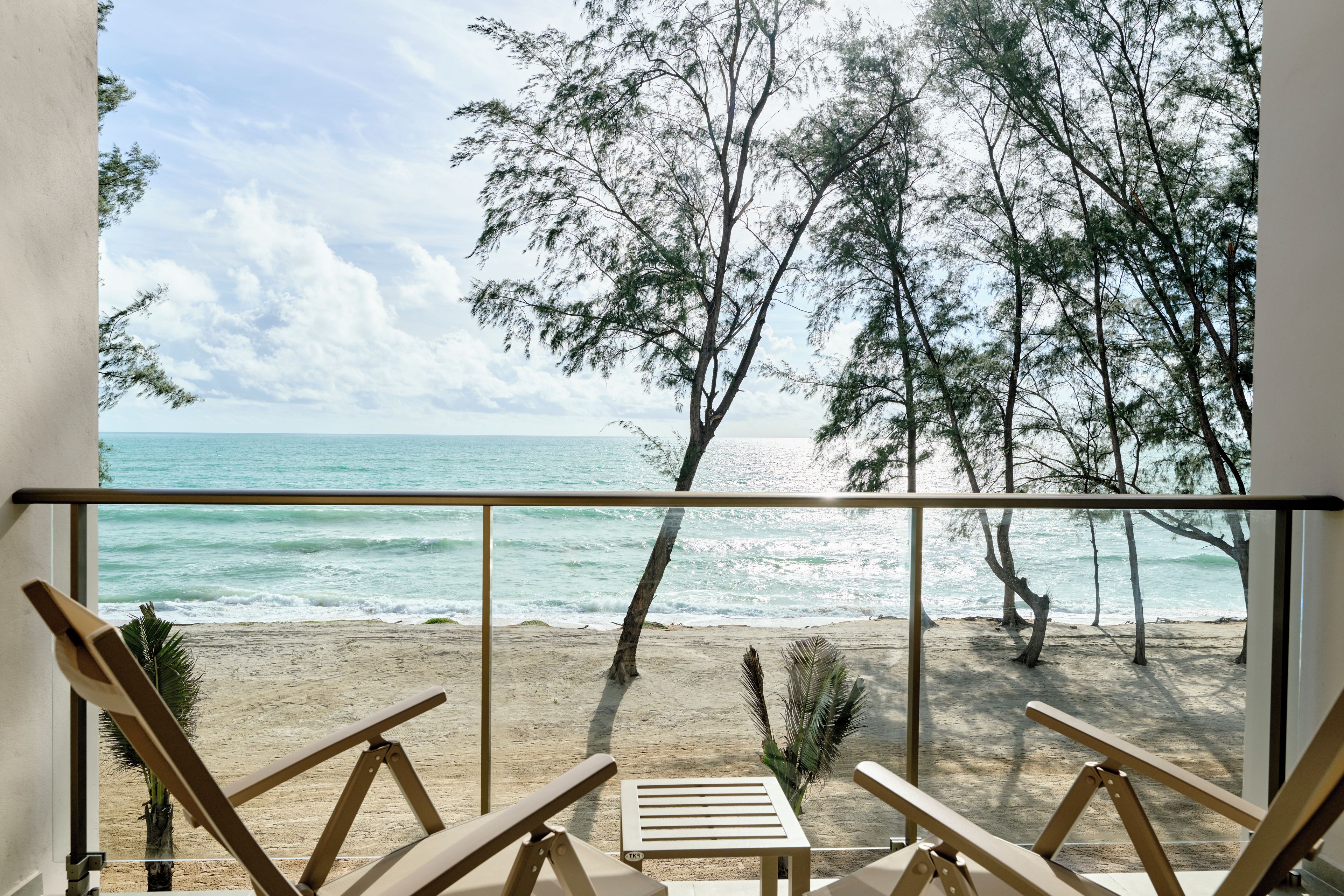 A balcony with a view of the beach and ocean.