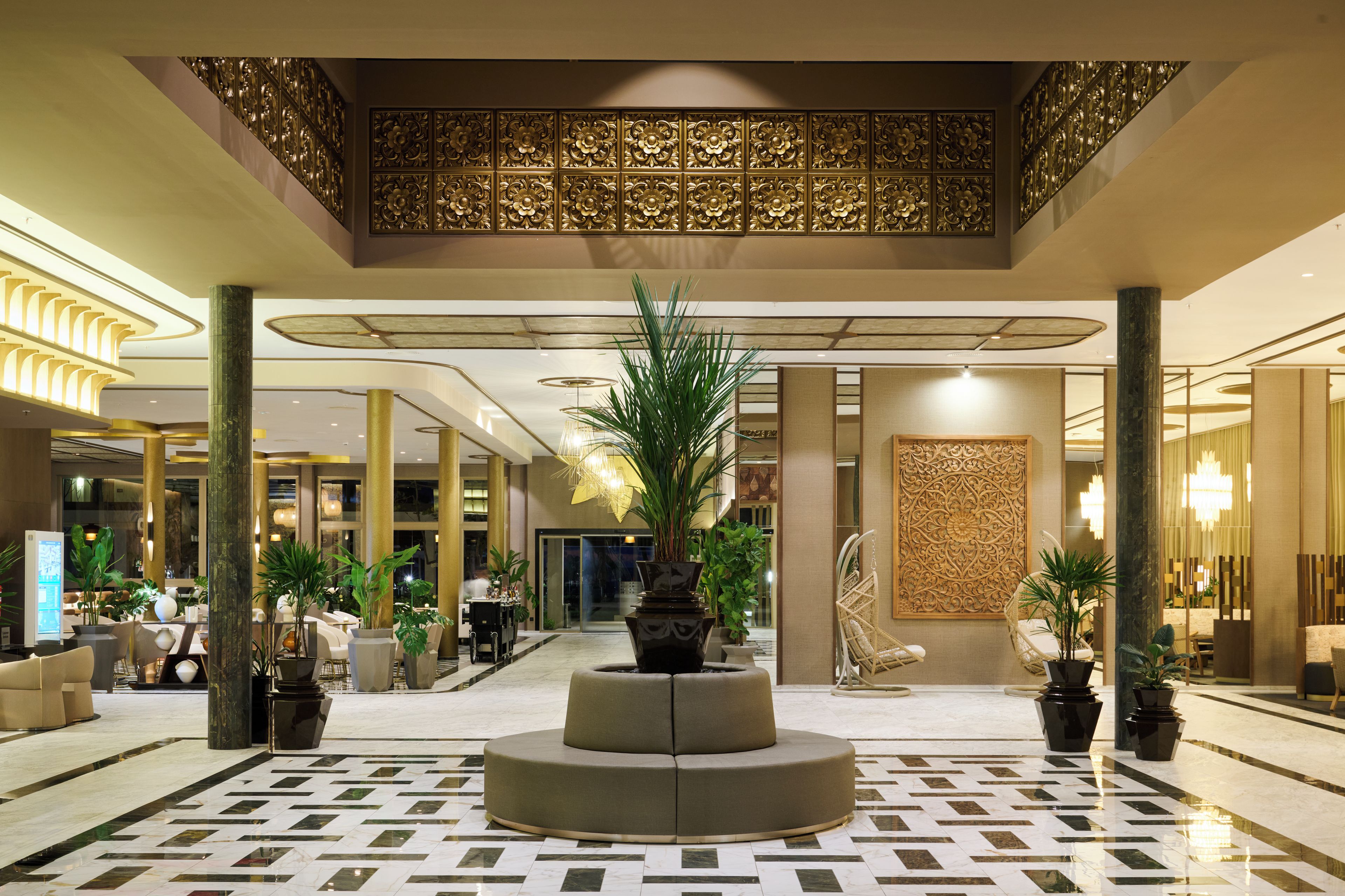 A spacious lobby with a central seating area, multiple columns, and a patterned floor.