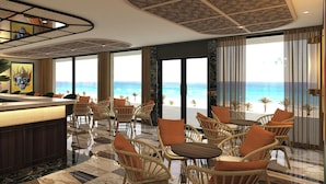 Ένα ξενοδοχειακό λόμπι με μπαρ, καρέκλες από μπαμπού και θέα στην παραλία.