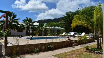 Een buitenzwembad, parasols voor strand/zwembad