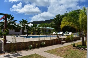 حمّام سباحة خارجي، مظلات على حمّام السباحة، مقاعد للتشمس