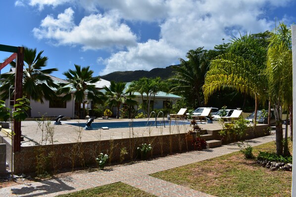Een buitenzwembad, parasols voor strand/zwembad