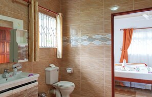 Standaard appartement | Badkamer | Een douche, een haardroger, handdoeken, toiletpapier