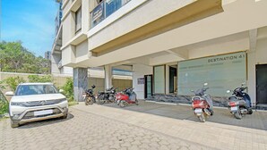 A building with a sign reading "DESTINATION 41" and a parked car and motorcycles in front. - Fabhotel Destination 41 (Pune)