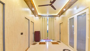 A hallway with a ceiling fan, recessed lighting, and a tiled floor with circular patterns.