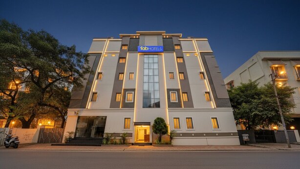 A modern hotel with a prominent 'fab hotels' sign, a central entrance, and a symmetrical facade with evenly spaced windows. - Fabhotel Pushpa Grand (Hyderabad)