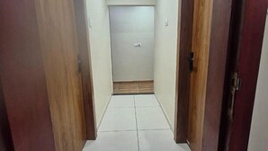 A narrow hallway with wooden doors on either side and a tiled floor. - Fabhotel Ripon Palace (Ujjain)
