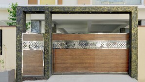 Een moderne garage met een houten deur en decoratieve metalen panelen.