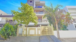A modern hotel with a flat roof, multiple balconies, and a gated entrance. - Fabhotel Casa Residency (Noida)