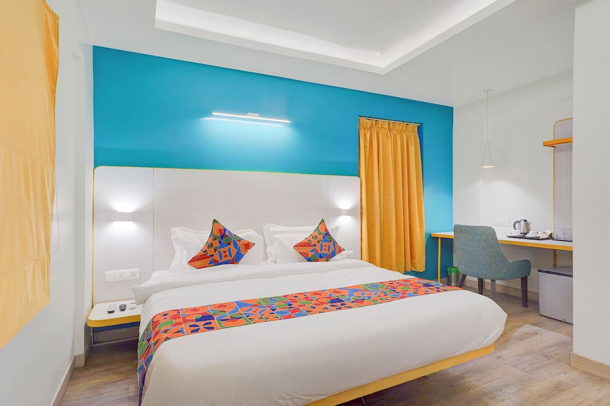 A hotel room with a bed, a desk, and a chair.