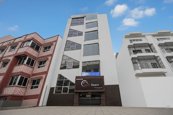 A modern hotel building with a prominent 'Fab Hotels' sign.