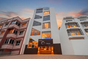 A modern hotel building with a prominent 'Fab Hotels' sign, multiple balconies, and a clear entrance.