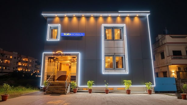 A modern building with a neon sign for 'Tab Hotels' and a 'Relais Inn' entrance. - Fabhotel Relax Inn (Shirur)