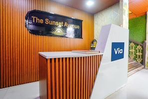 A reception desk with a sign reading 'The Sunset Avenue' and a 'Via' logo. - Via The Sunset Avenue Mumbai (Mumbai)