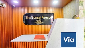 Una mesa de recepción con un cartel que dice 'The Sunset Avenue' y un cartel de 'Via'.
