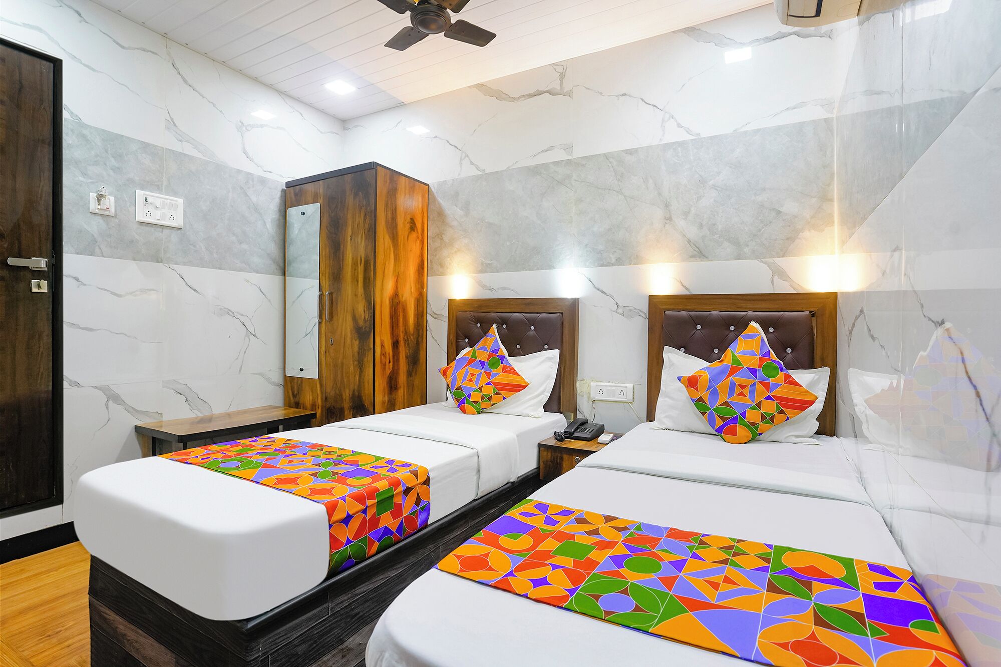 Habitación de hotel con dos camas, un armario y un espejo.