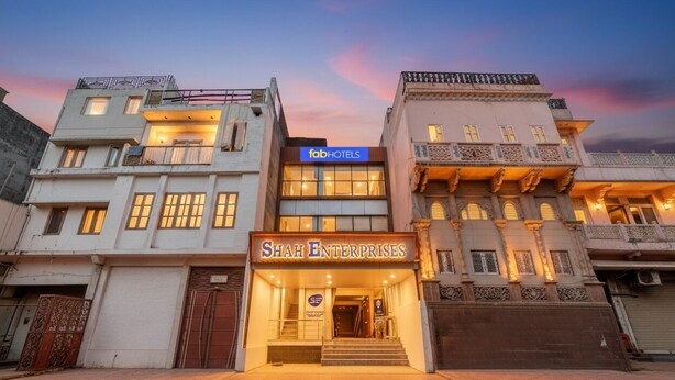 Eine Hotelansicht mit den Schildern 'fabHOTELS' und 'SHAH ENTERPRISES', die einen modernen Eingang und traditionelle architektonische Elemente zeigt.