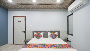 Ein Hotelzimmer mit Bett, Nachttisch und Klimaanlage.