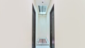 Un pasillo estrecho con un tragaluz y una ventana pequeña al final.