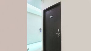 Puerta cerrada con placa que indica el número 202, un picaporte de metal y una cerradura.