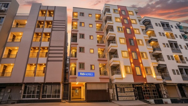 A multi-story hotel with balconies, a visible 'fabHOTELS' sign, and a sunset sky. - Fabhotel Golden Eagle Executive (Paud)