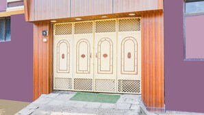 A building entrance with a wooden door and a green mat. - Fabhotel Dream Inn (Danapur)