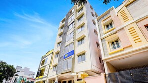 A multi-story hotel with a prominent 'fbt hotels' sign, a gated entrance, and a clear sky. - Fabhotel Ak Elite Luxury Homestay (Tirupati)