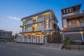 A modern hotel with a sign reading "fabHOTELS". It features a multi-story structure with balconies and large windows. - Fabhotel Galaxy Greno Celebration (Greater Noida)