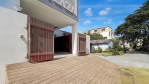 A modern building with a wooden deck leading to a gated entrance. - Fabhotel Kayal Plaza (Coimbatore)