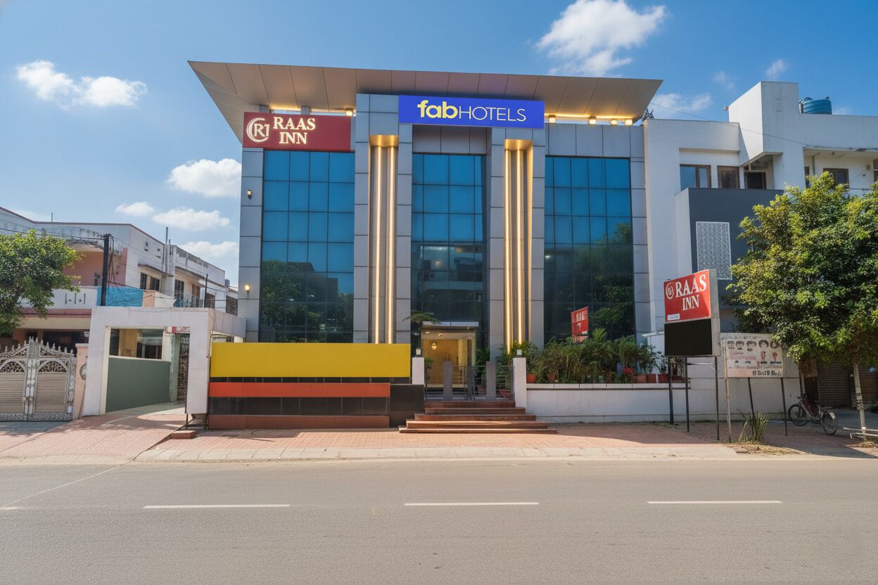 A modern building with a glass facade, featuring signage for 'RAAS INN' and 'fabHOTELS'.