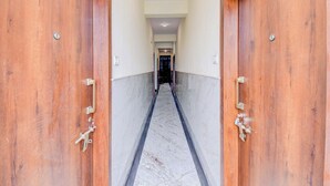 Ένας διάδρομος με ξύλινες πόρτες και μαρμάρινο δάπεδο.