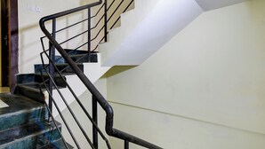Eine Treppe mit schwarzen Metallgeländern und weißen Wänden.