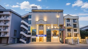 A modern hotel with a prominent entrance, multiple balconies, and a sign reading "fabHOTELS". - Fabhotel Crescent (Faridabad)