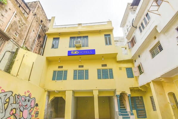 A yellow building with a sign reading "fabHOTELS" and a staircase leading to the entrance. - Fabhotel Pink Cozzy (Jaipur)