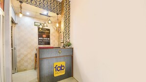 A reception desk with a sign for 'Fab Hotels'. - Fabhotel Lotus Inn (Faridabad)