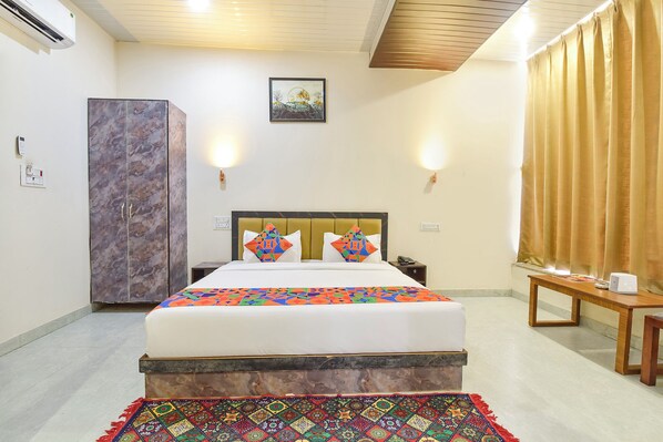 A hotel room with a bed, a wardrobe, a desk, and a wall-mounted picture. - Fabhotel Sunroof & Rooftop (Jaipur)